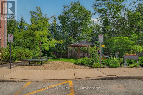 A park with a gazebo, bench, and trees.