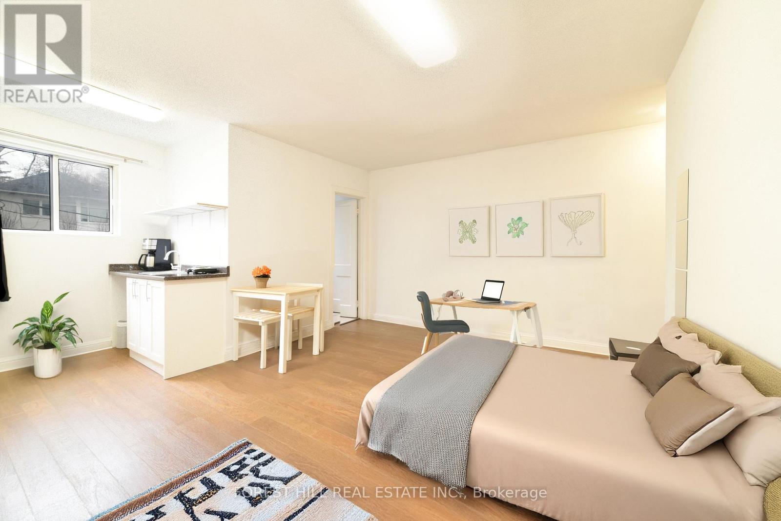 A bedroom with a bed, desk, and chair.