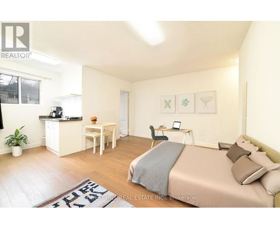 A bedroom with a bed, desk, and chair.