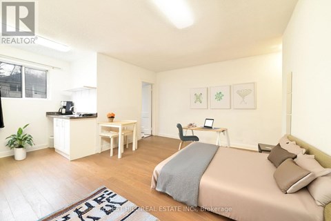 A bedroom with a bed, desk, and chair.