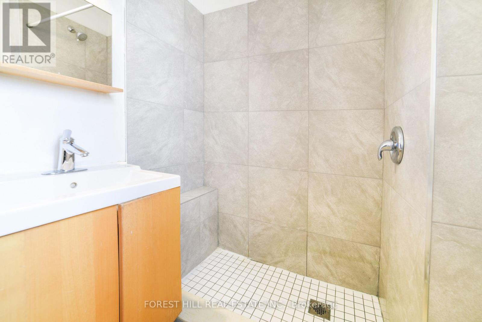 A bathroom with a white sink and a tiled floor.