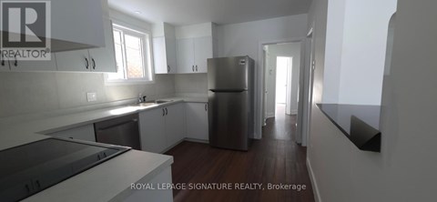 A kitchen with white cabinets and a stainless steel refrigerator.