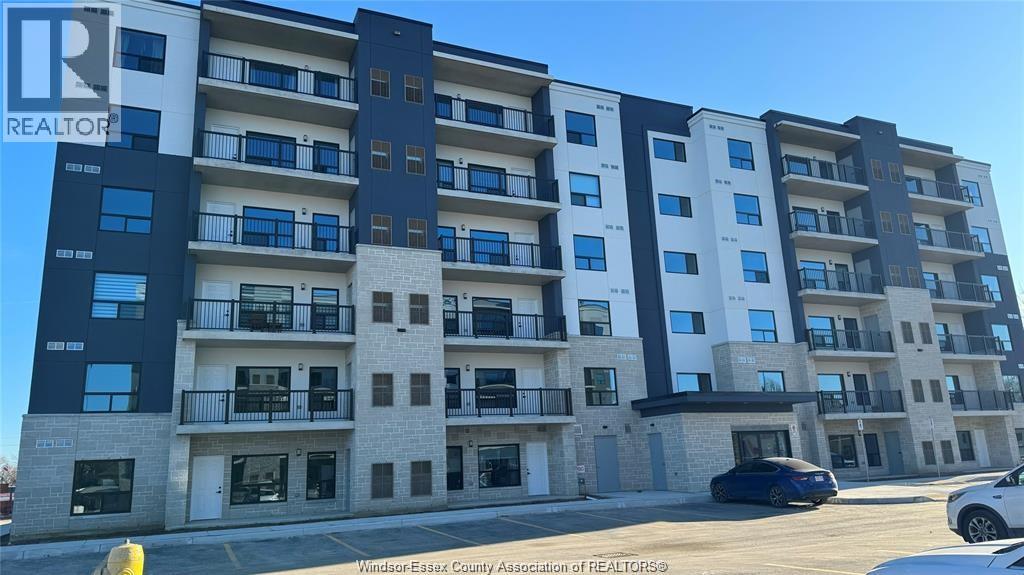 A large apartment building with multiple balconies and doors.