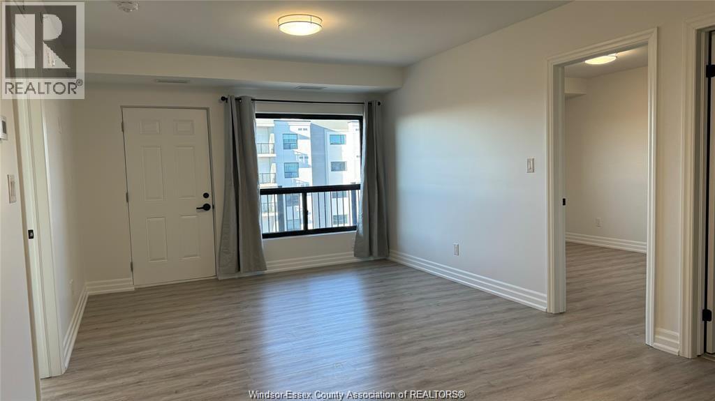 A spacious room with a sliding glass door leading to a balcony.