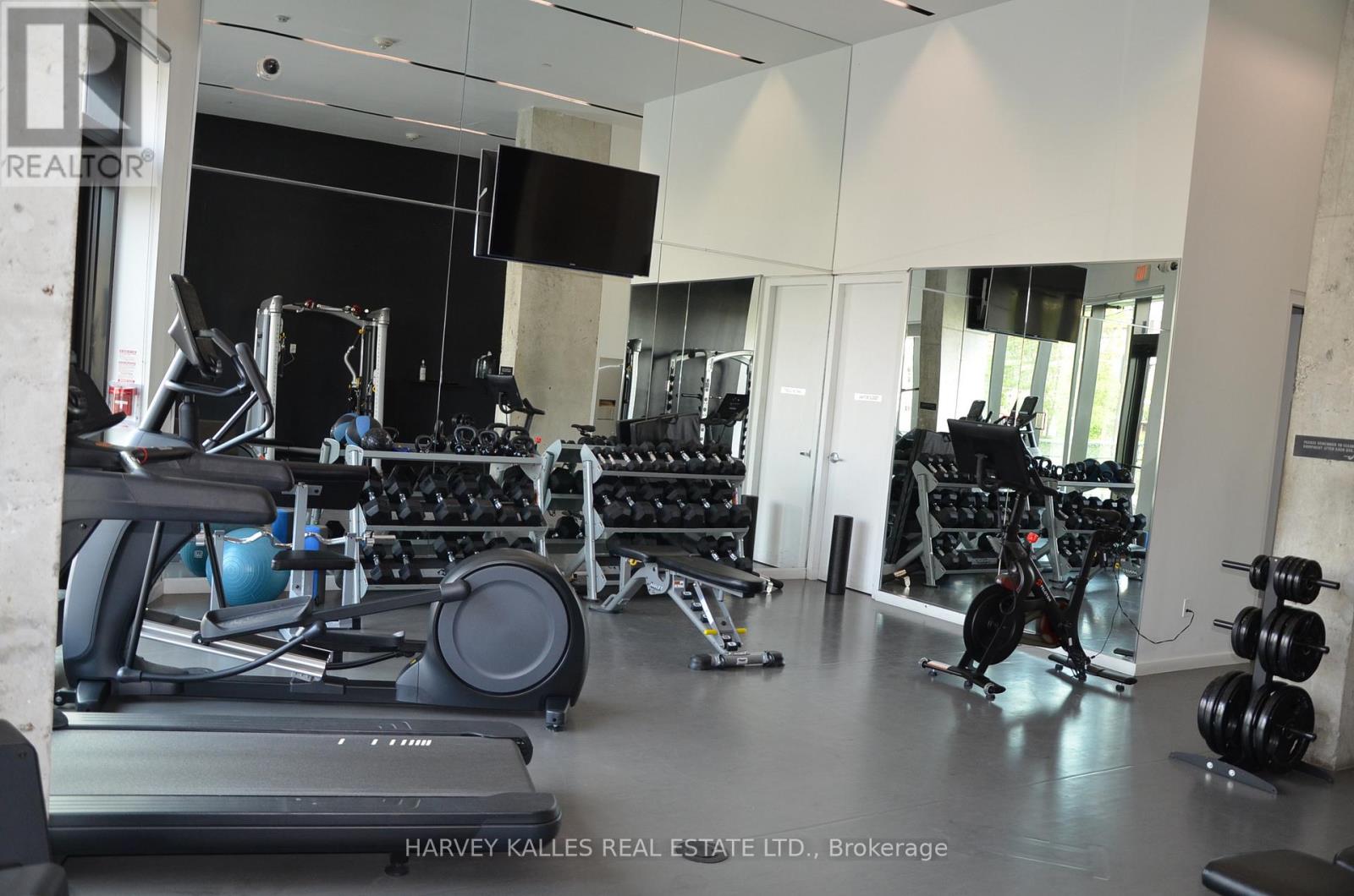 A gym with a variety of equipment including treadmills, weights, and exercise machines.