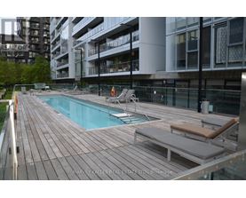 A wooden deck with a pool and lounge chairs.