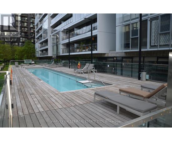 A wooden deck with a pool and lounge chairs.