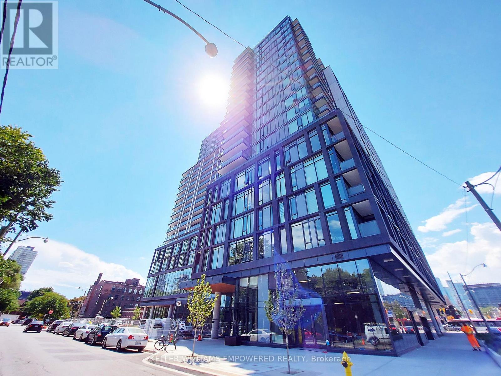 A tall building with many windows is being constructed on a city street.