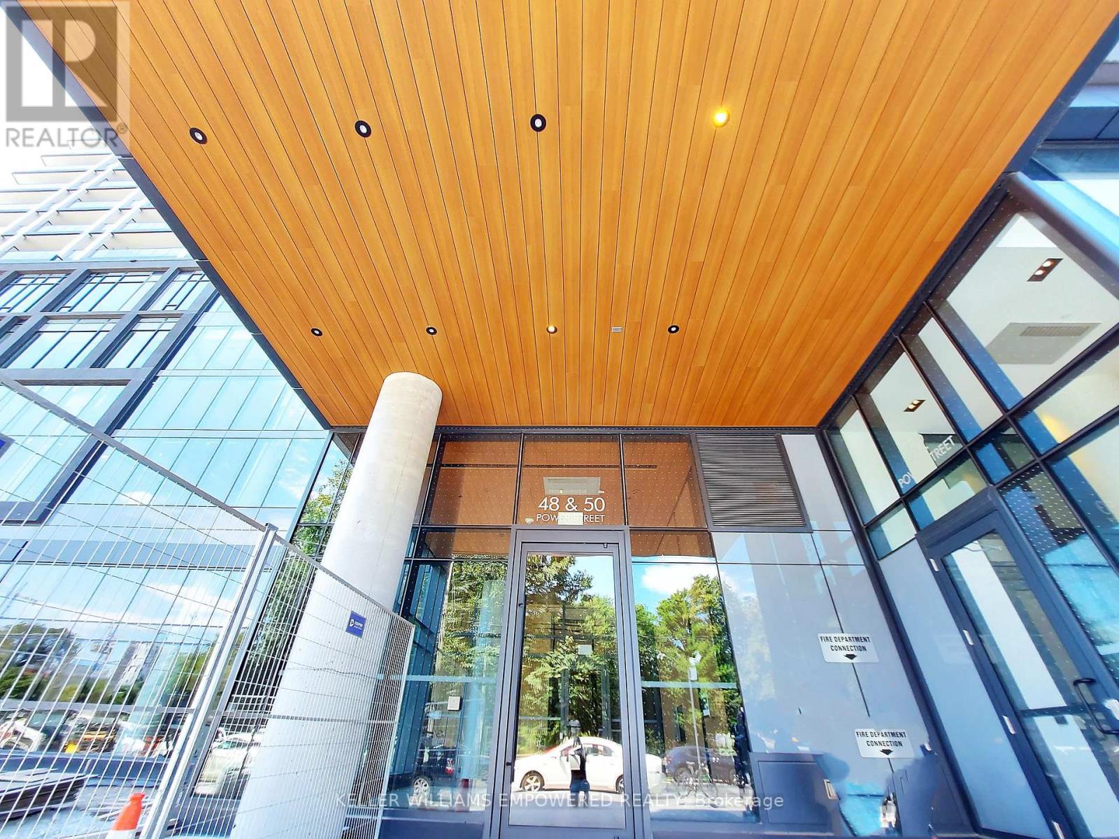 The entrance to a building with a glass door and a wooden ceiling.