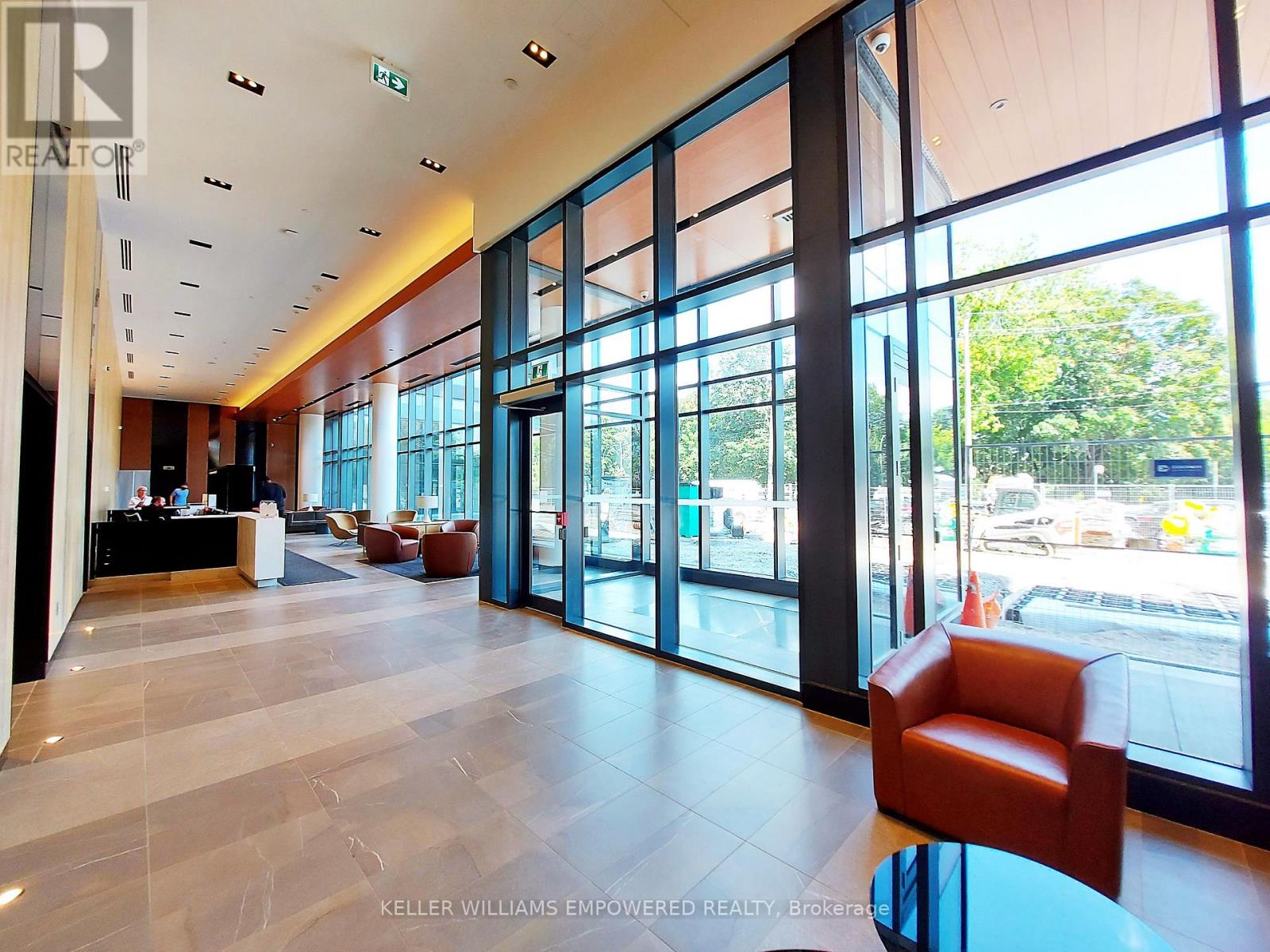 A spacious office lobby with a reception desk and a large glass wall.