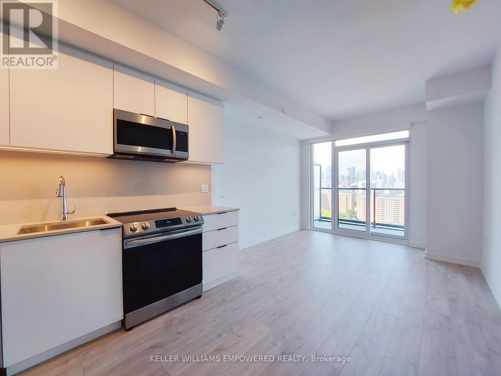 A kitchen with white cabinets and a black stove top oven.