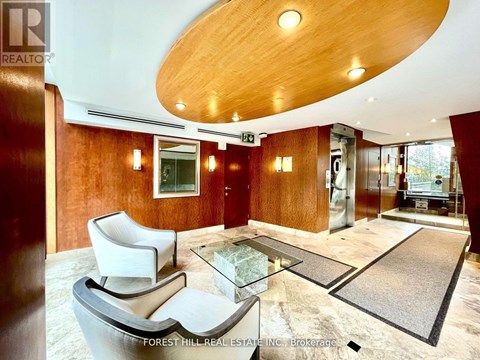 A modern living room with a glass table and a wooden ceiling.