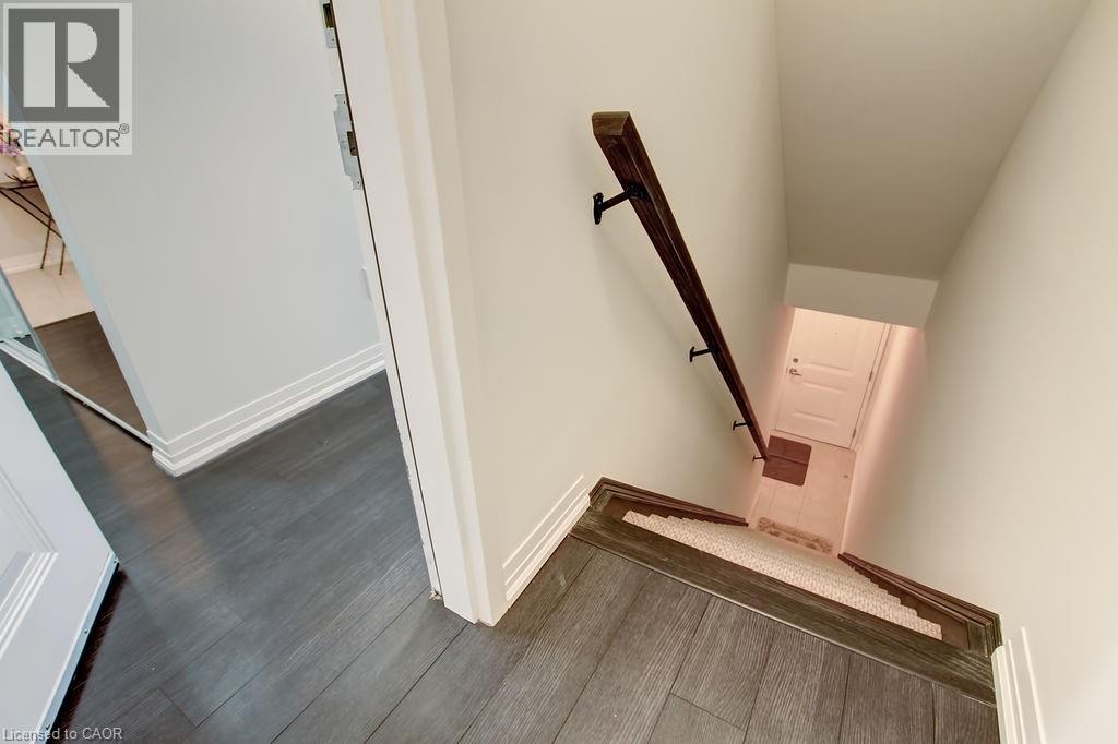 A stairway with a wooden handrail and a white wall.
