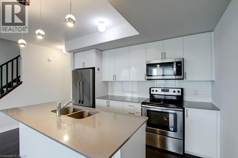 A modern kitchen with a stainless steel oven and microwave.
