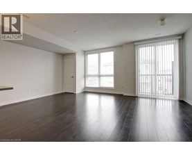 A spacious room with wooden floors and white walls.