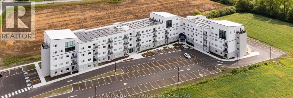 A large white building with a parking lot in front.