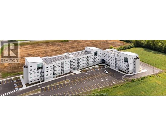 A large white building with a parking lot in front.