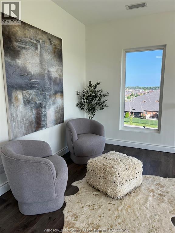 A living room with two grey chairs and a large abstract painting on the wall.