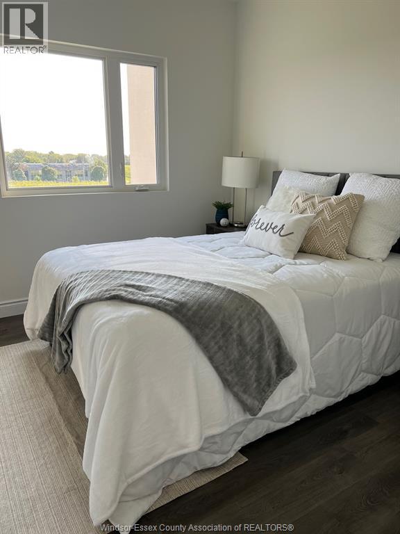 A bedroom with a large bed and a window overlooking a field.
