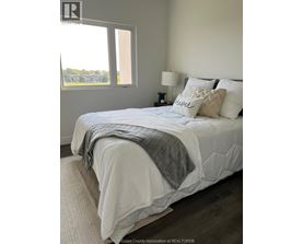 A bedroom with a large bed and a window overlooking a field.
