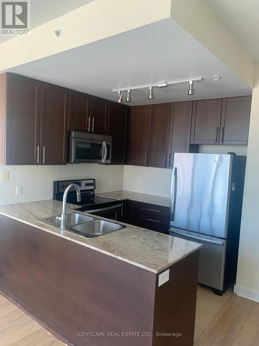 A kitchen with brown cabinets and a granite counter top.