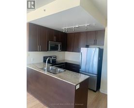 A kitchen with brown cabinets and a granite counter top.