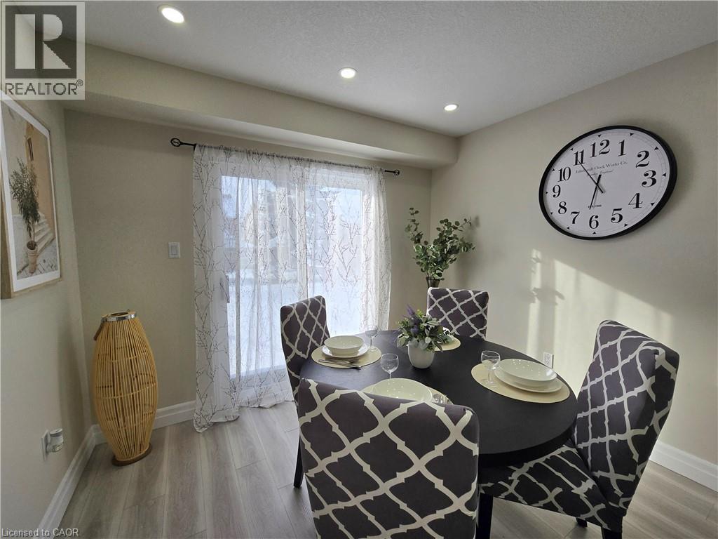 A dining room with a table set for two and a clock on the wall.