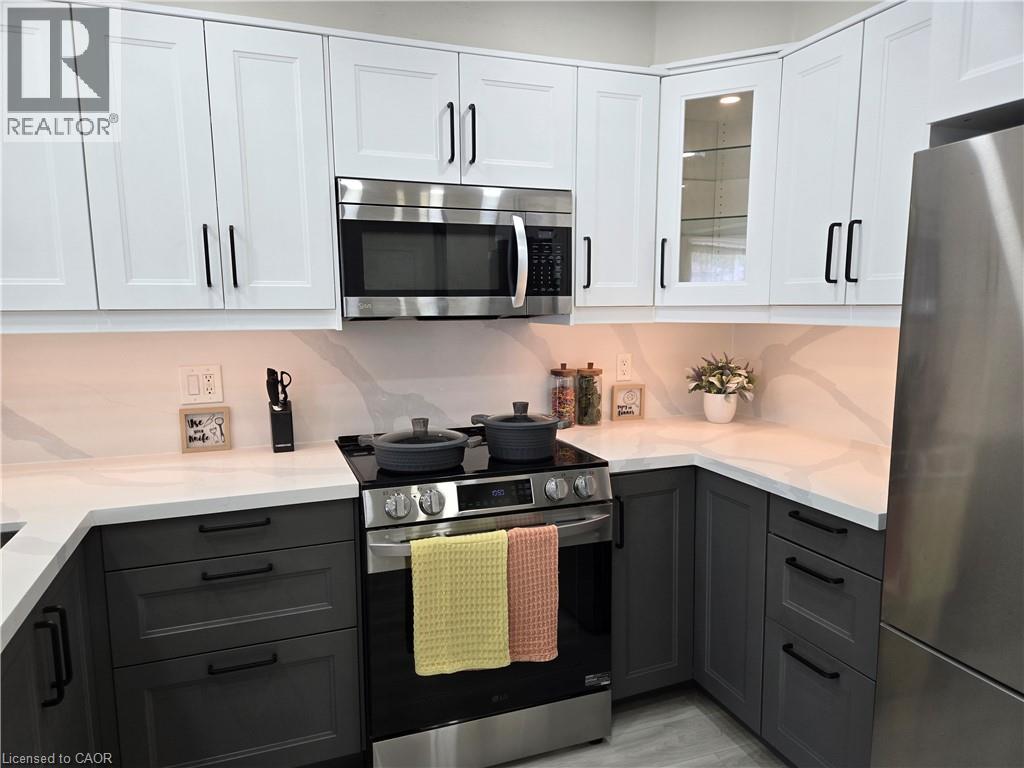 A modern kitchen with a black stove top oven and white cabinets.