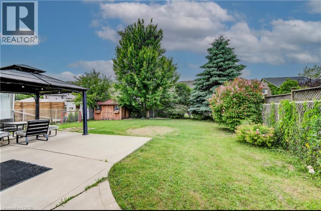 A backyard with a picnic table and a gazebo.