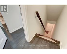 A stairway with a wooden handrail and a white door at the top.