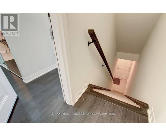 A stairway with a wooden handrail and a white door at the top.