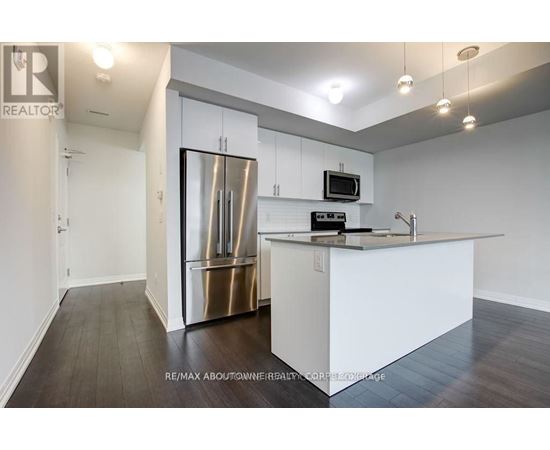 A modern kitchen with white cabinets and a stainless steel refrigerator.