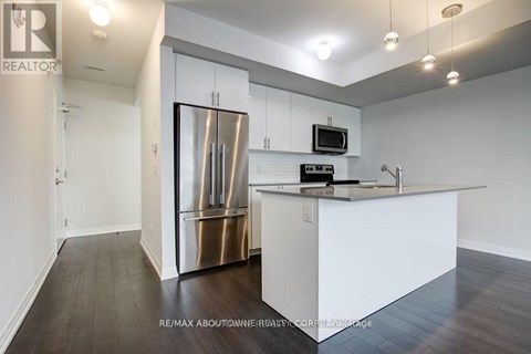 A modern kitchen with white cabinets and a stainless steel refrigerator.