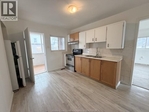 A kitchen with wooden cabinets and a microwave on the counter.