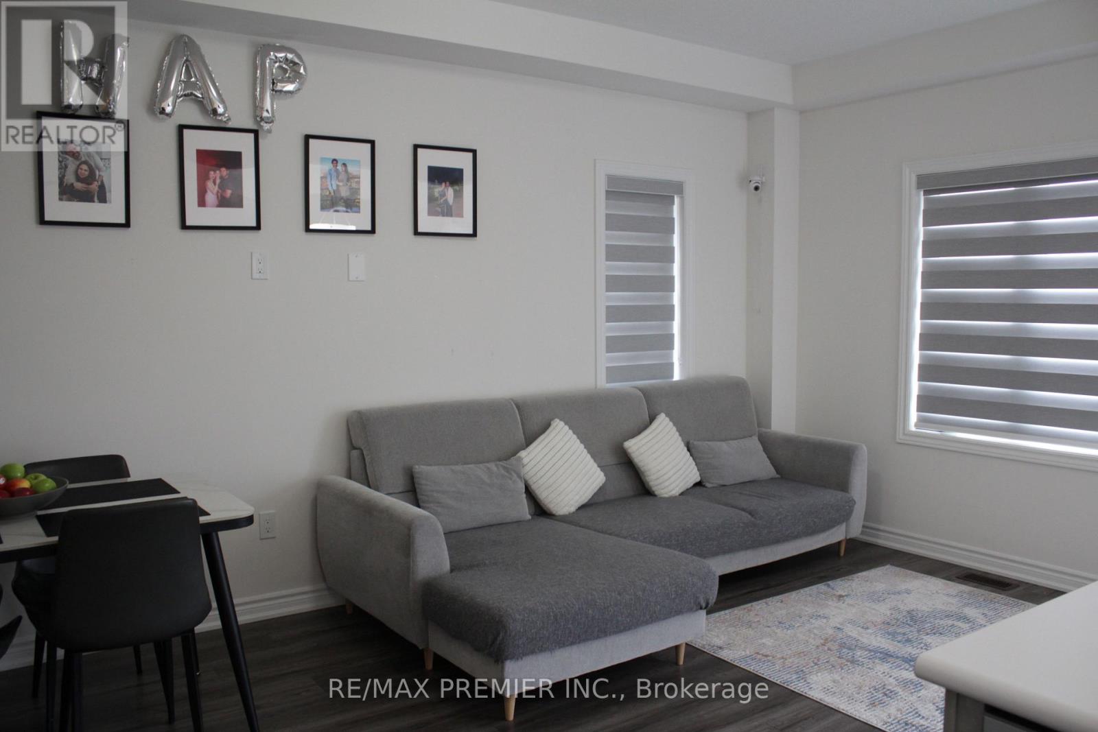 A living room with a grey couch and a dining table.
