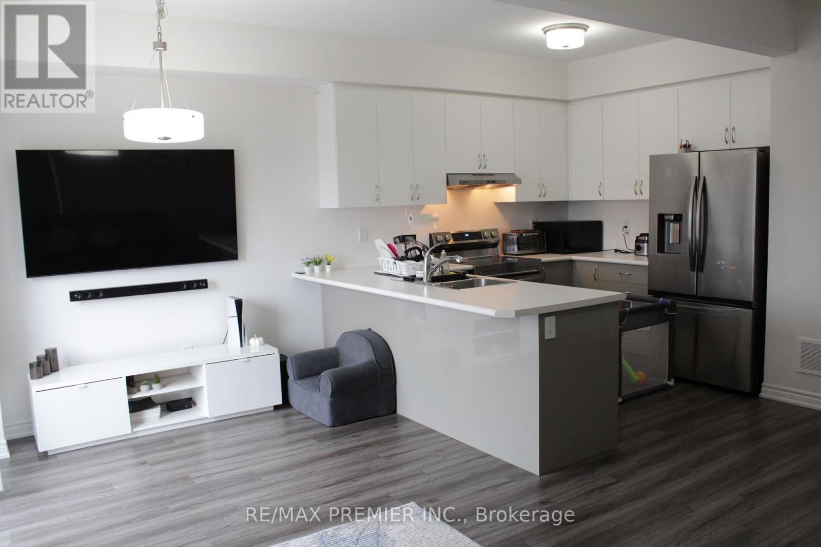 A modern kitchen with white cabinets and a grey island.