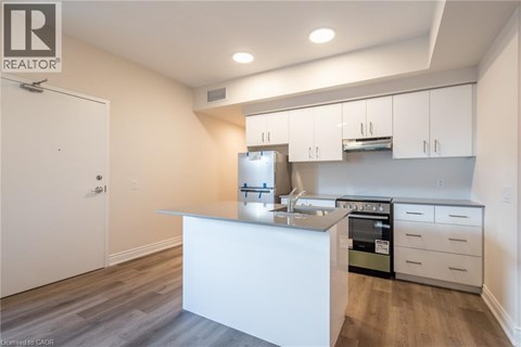 A white kitchen with a sink and stove.