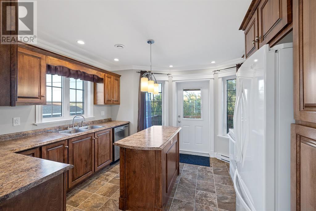 A kitchen with wooden cabinets and a marble countertop.