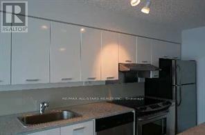 A kitchen with white cabinets and a sink.
