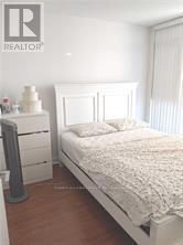 A bedroom with a bed, nightstand and a dresser.