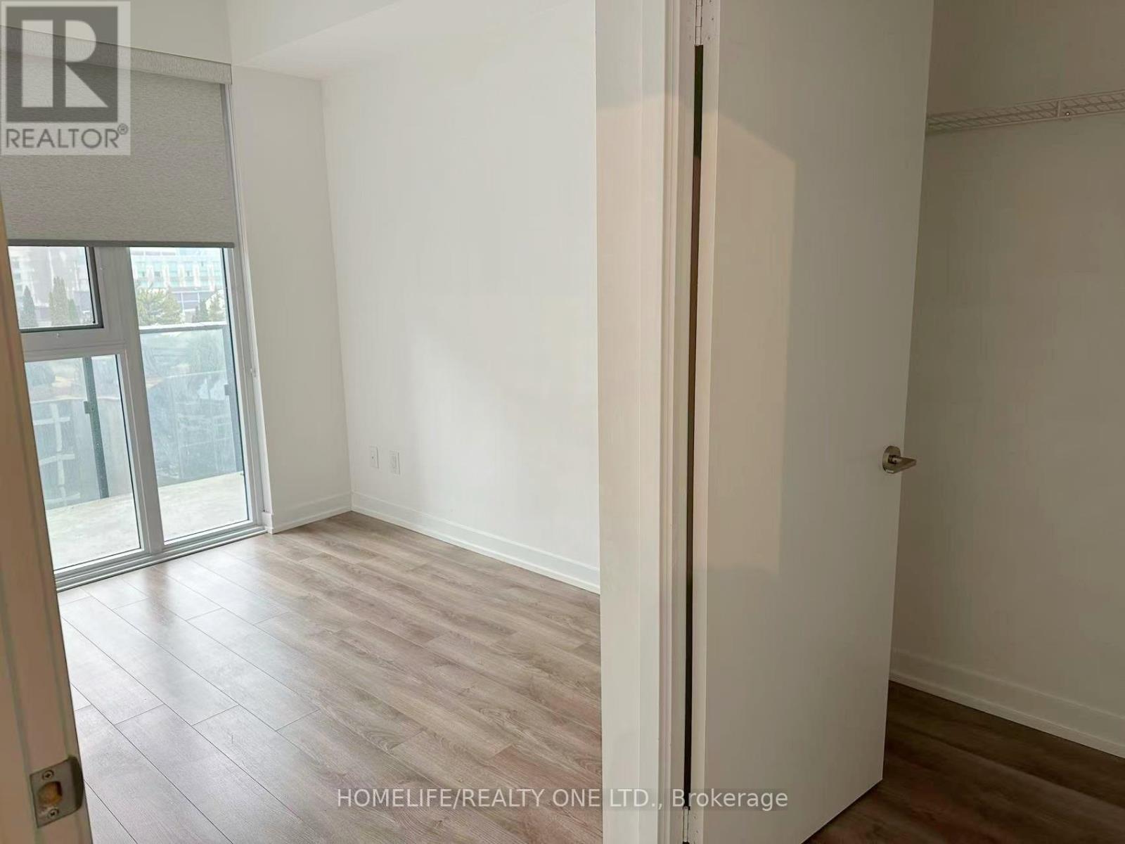 A room with a sliding glass door leading to a balcony.