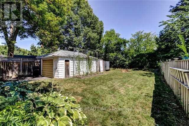 A backyard with a shed and a fence.