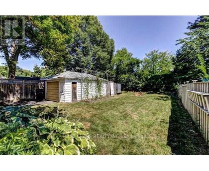 A backyard with a shed and a fence.