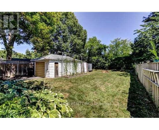 A backyard with a shed and a fence.
