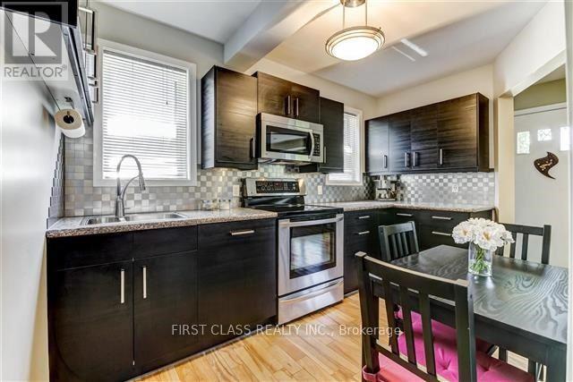 A kitchen with black cabinets and a wooden table.
