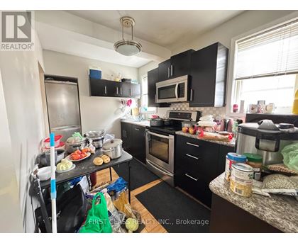 A kitchen with black cabinets and a wooden table.