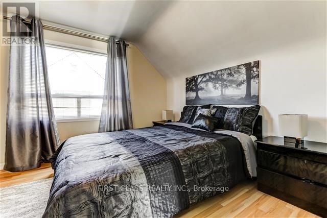 A bedroom with a large bed and a large picture on the wall.