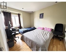 A bedroom with a large bed and a large picture on the wall.