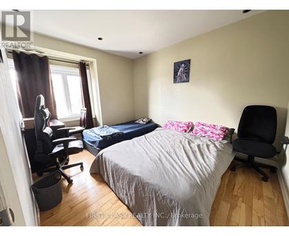A bedroom with a large bed and a large picture on the wall.