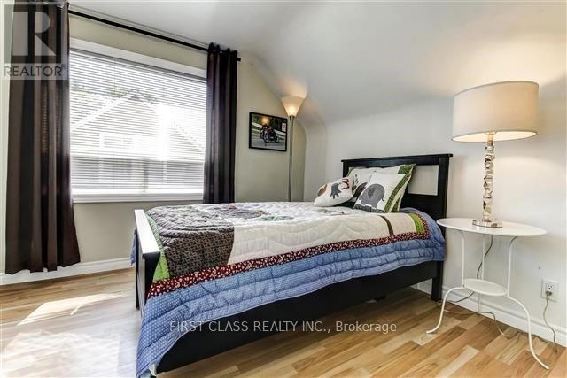 A bedroom with a bed, nightstand, and window.